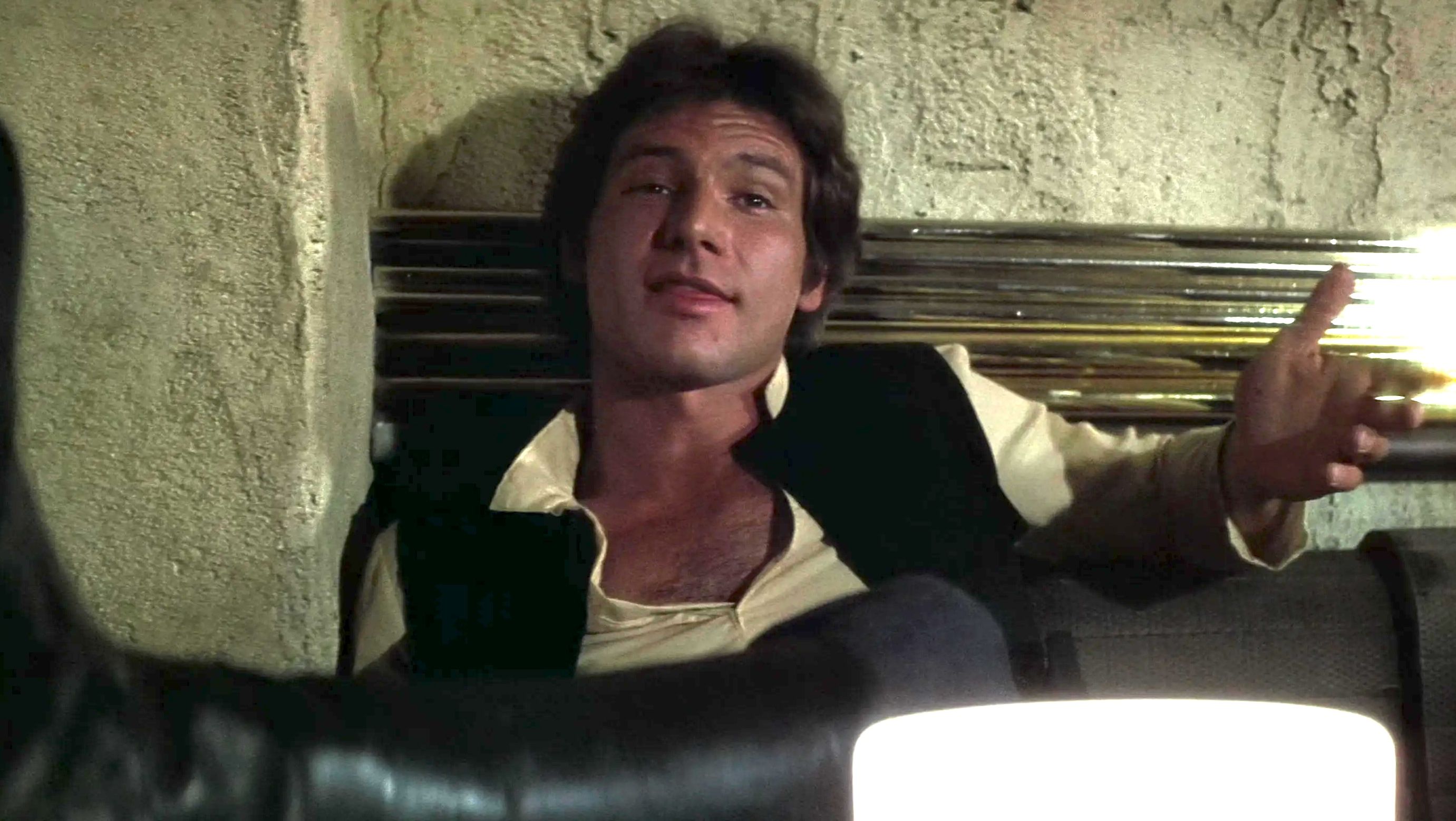 Han Solo sitting in his cantina bar seat getting ready to shoot Greedo in Star Wars: A New Hope